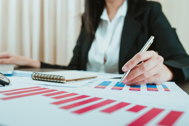 Sección media de una mujer de negocios trabajando en un gráfico en la oficina