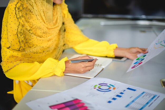 Sección media de una mujer de negocios trabajando sobre un gráfico en la mesa