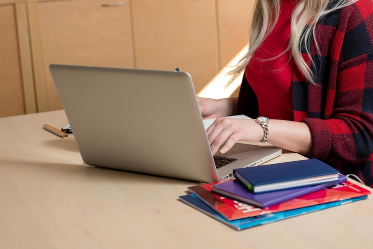 Foto sección media de una mujer de negocios usando una computadora portátil en la mesa en la oficina
