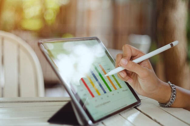 Sección media de una mujer de negocios usando una tableta digital en la mesa