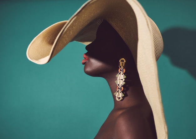 Sección media de una mujer negra con un gran sombrero de sol y pendientes de declaración