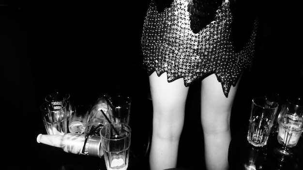 Sección media de una mujer de pie por las bebidas en un club nocturno
