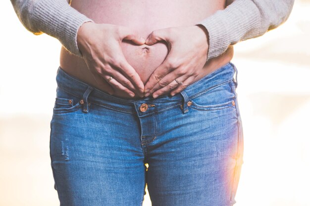 Sección media de una mujer de pie contra la pared