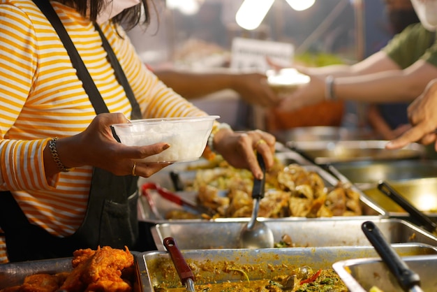 Sección media de una mujer preparando comida en la parrilla de barbacoa