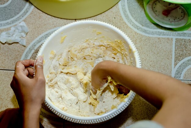 Foto sección media de una mujer preparando comida en un plato en la mesa