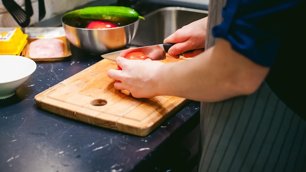 Sección media de una mujer preparando comida en la tabla de cortar