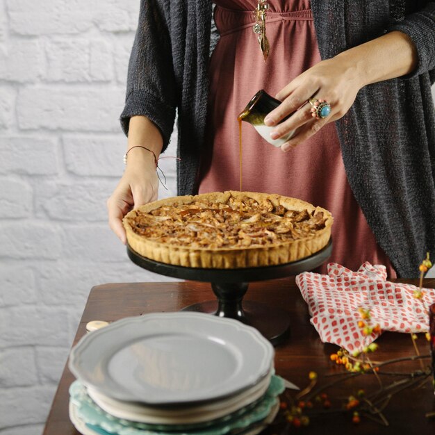 Foto sección media de una mujer preparando una tarta dulce