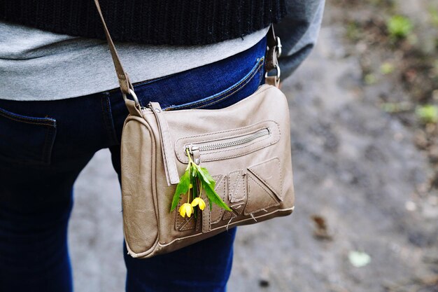 Sección media de una mujer que lleva un bolso