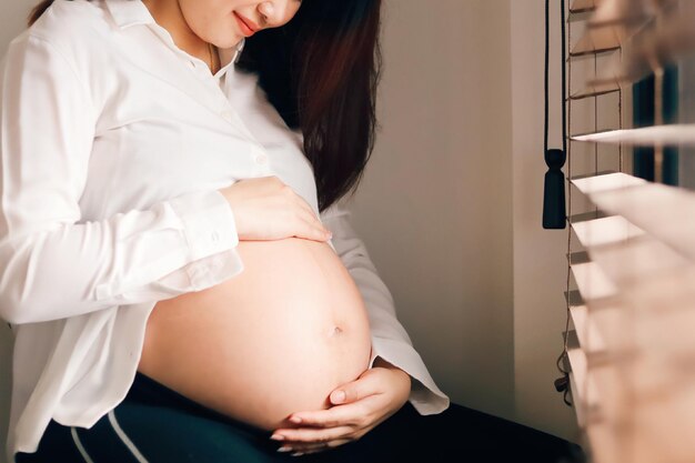 Foto sección media de una mujer que se sostiene de la mano