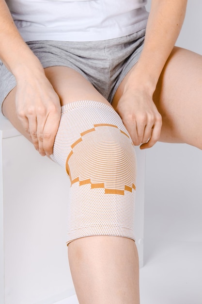 Sección media de una mujer que sufre de dolor en la rodilla