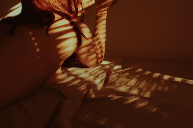 Sección media de una mujer relajándose en la cama en casa