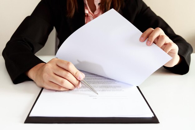 Foto sección media de una mujer señalando un documento