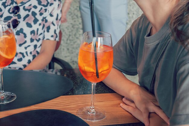 Foto sección media de una mujer sosteniendo una bebida en la mesa en un restaurante