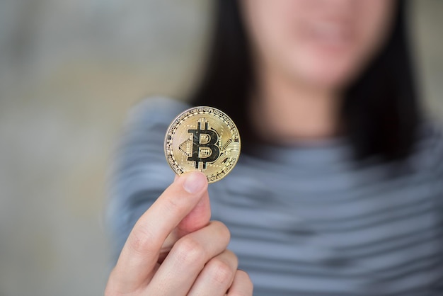 Sección media de una mujer sosteniendo bitcoin
