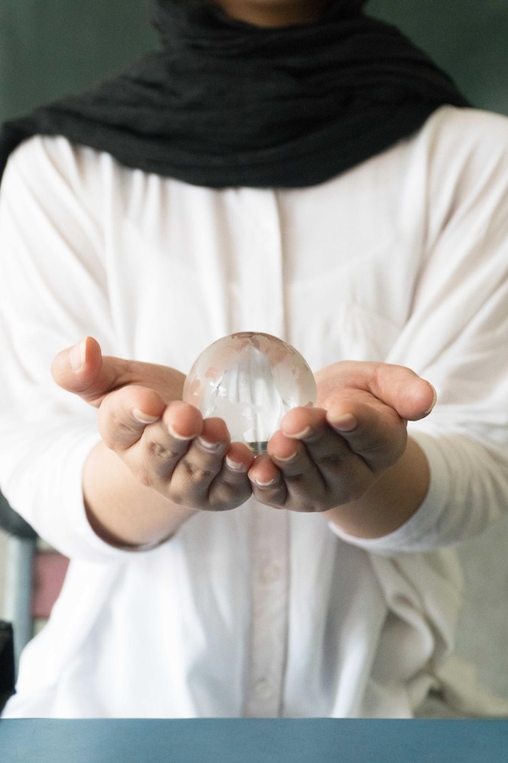 Foto sección media de una mujer sosteniendo una bola de cristal