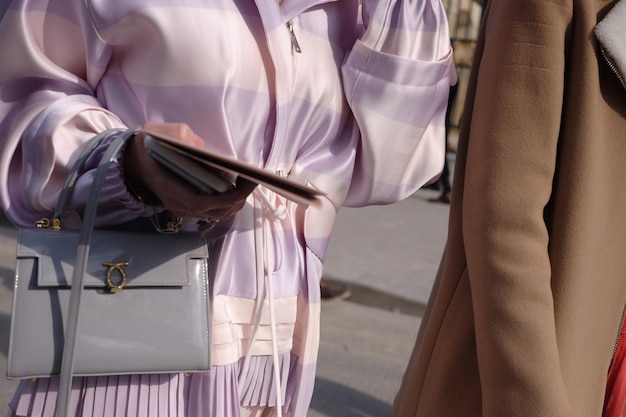 Sección media de una mujer sosteniendo un bolso en la calle