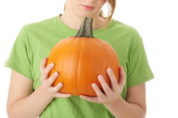 Foto sección media de una mujer sosteniendo una calabaza contra un fondo blanco