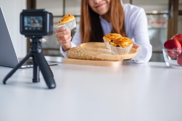 Foto sección media de una mujer sosteniendo comida mientras está sentada en la mesa