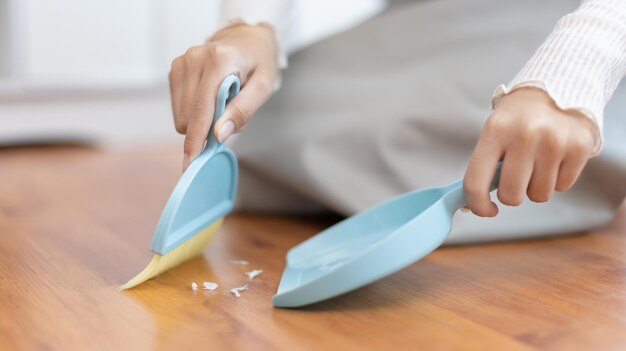 Sección media de una mujer sosteniendo dentaduras dentales en la mesa