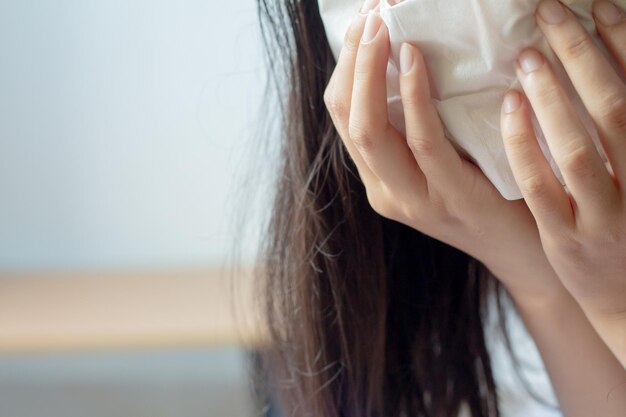 Sección media de una mujer sosteniendo un pañuelo de papel