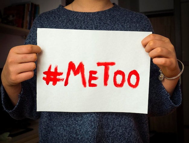 Sección media de una mujer sosteniendo un papel con texto
