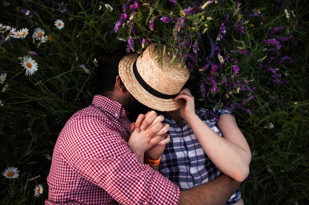 Foto sección media de una mujer sosteniendo plantas de flores púrpuras en el campo