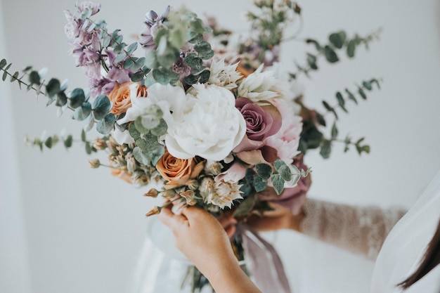 Sección media de una mujer sosteniendo un ramo de flores mientras está de pie al aire libre