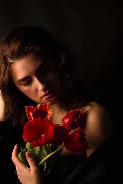 Foto sección media de una mujer sosteniendo un ramo de rosas