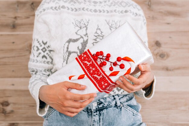 Foto sección media de una mujer sosteniendo un regalo de navidad