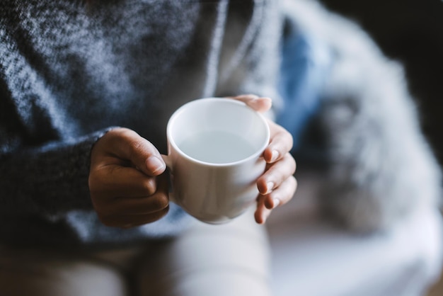 Sección media de una mujer sosteniendo una taza de café