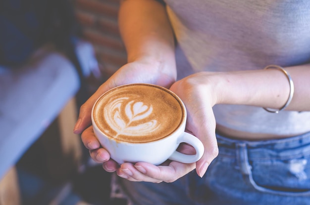 Sección media de una mujer sosteniendo una taza de café