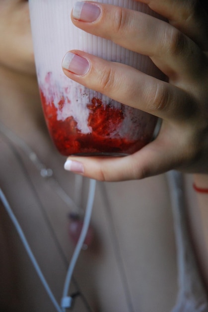 Foto sección media de una mujer sosteniendo vidrio desechable