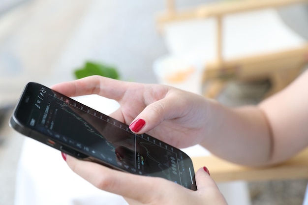 Sección media de una mujer con un teléfono inteligente