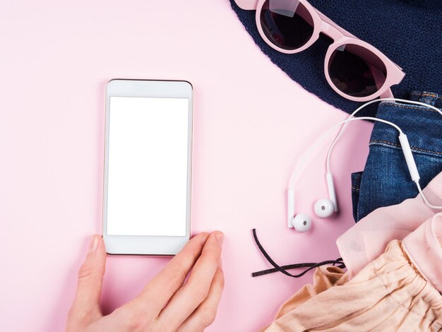 Sección media de una mujer con un teléfono móvil