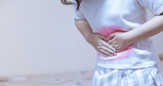 Sección media de la mujer tocando el abdomen con dolor