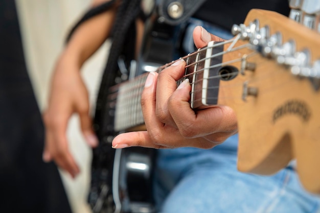 Foto sección media de una mujer tocando la guitarra eléctrica