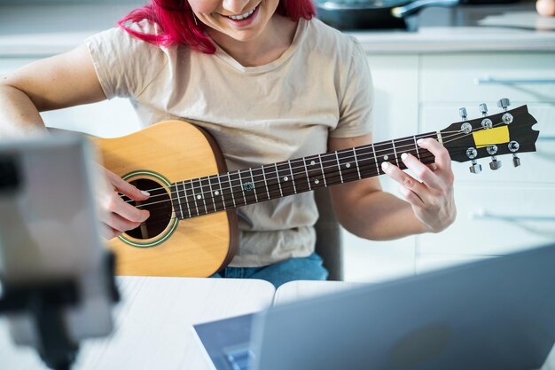 Sección media de una mujer tocando la guitarra