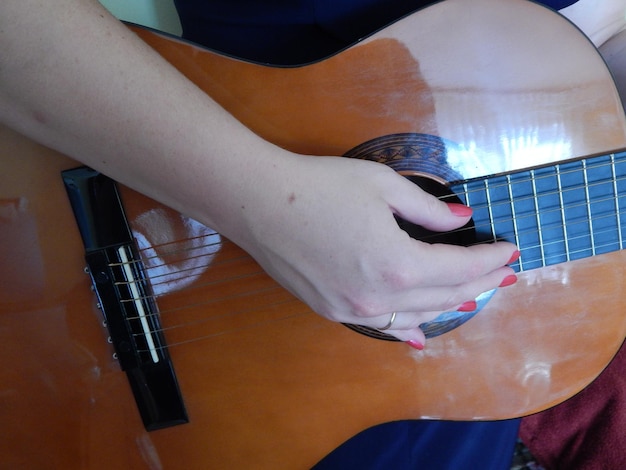 Foto sección media de una mujer tocando la guitarra