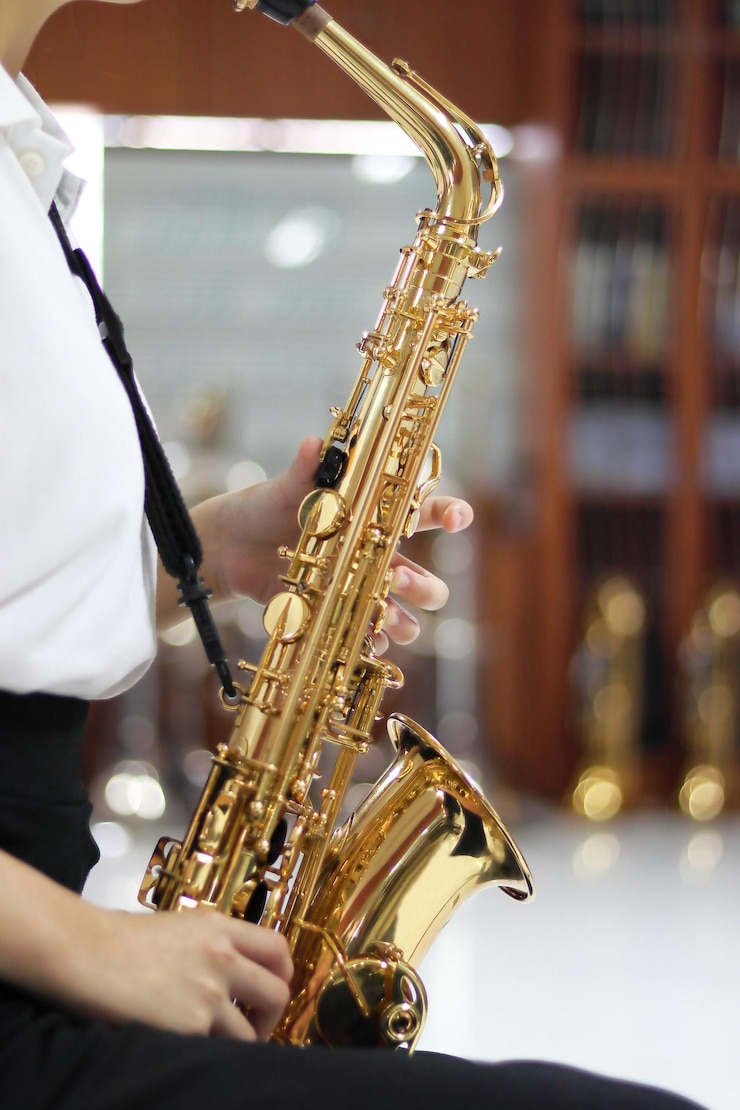Foto sección media de una mujer tocando el saxofón en un concierto de música