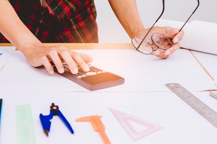 Foto sección media de una mujer usando una calculadora en la mesa