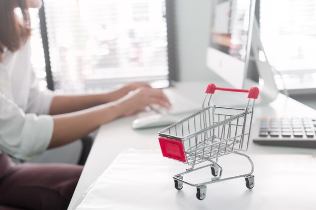 Sección media de una mujer usando una computadora en la oficina