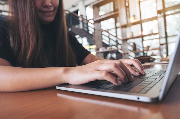 Sección media de una mujer usando una computadora portátil en casa