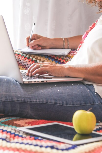 Foto sección media de una mujer usando una computadora portátil en casa