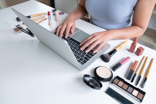 Sección media de una mujer usando una computadora portátil en el escritorio