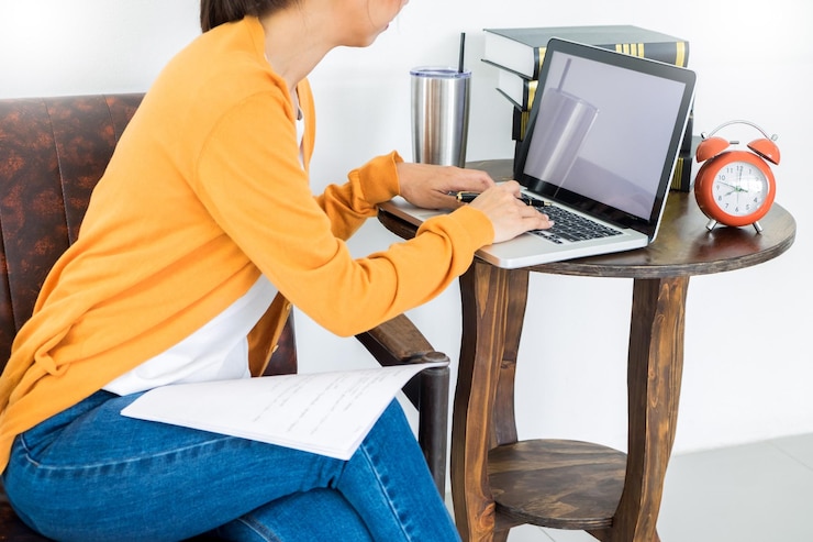 Foto sección media de una mujer usando una computadora portátil en la mesa en casa
