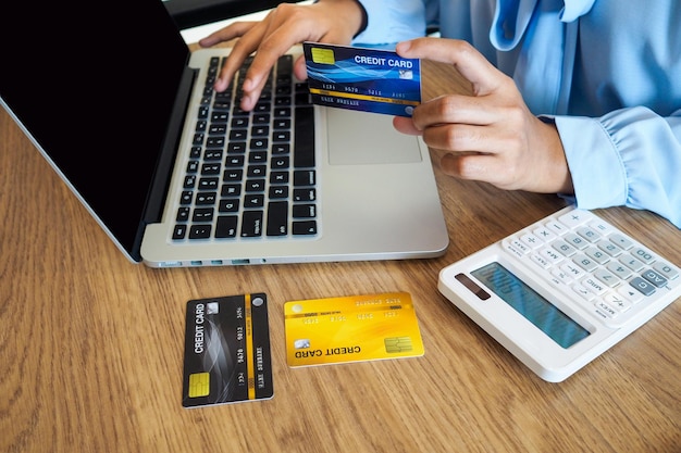 Sección media de una mujer usando una computadora portátil en la mesa
