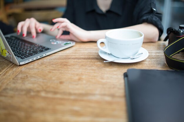 Foto sección media de una mujer usando una computadora portátil en la mesa