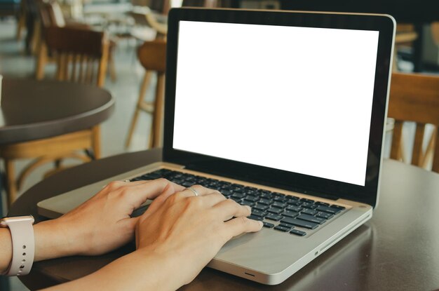 Foto sección media de una mujer usando una computadora portátil en la mesa