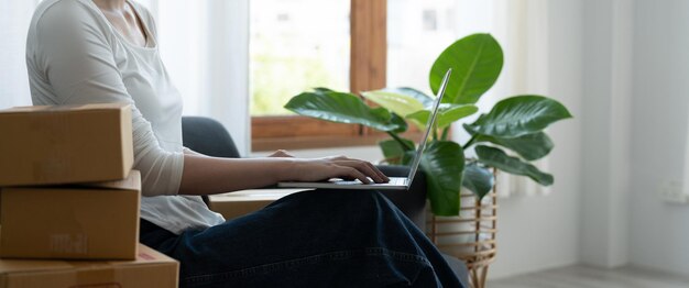 Sección media de una mujer usando una computadora portátil en la mesa