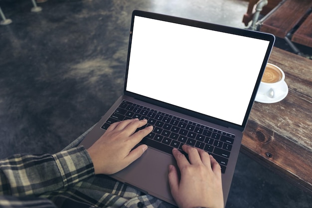 Sección media de una mujer usando una computadora portátil en la mesa